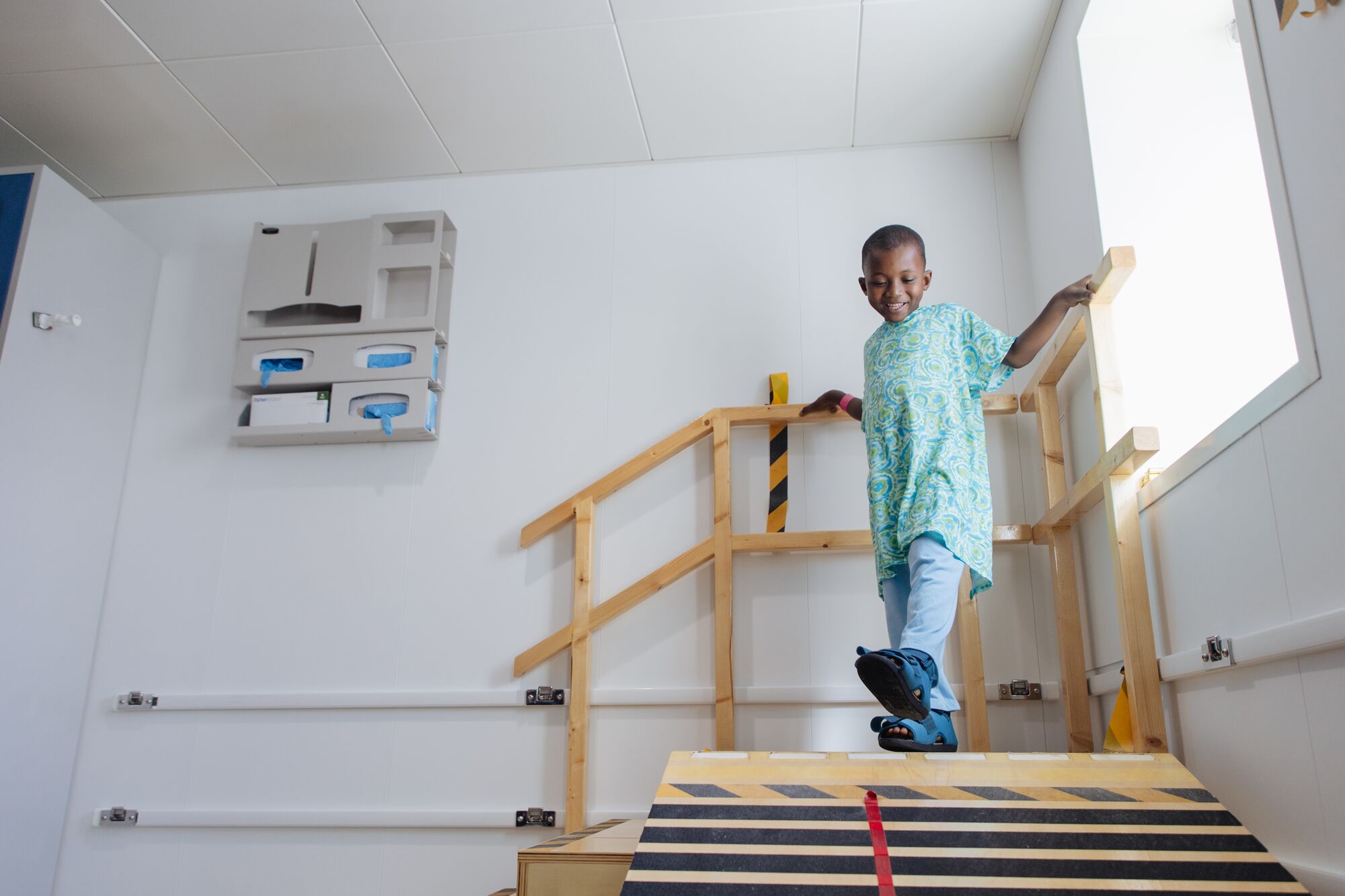 Steg för steg började Abubakarr gå igen i speciella rehabiliteringsskor, med stöd av rehabiliteringsteamet.